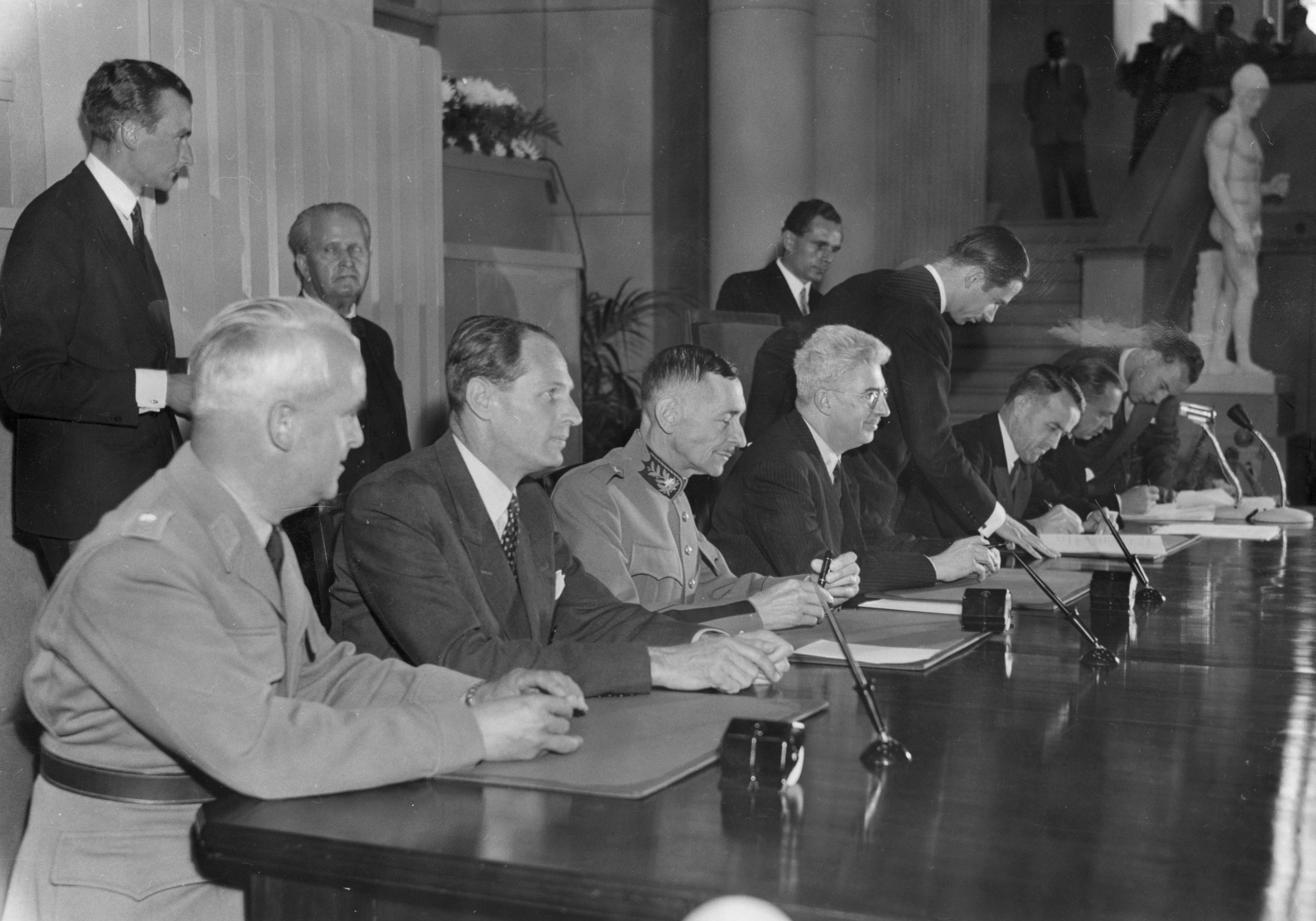 The Swiss delegation, in the presence of Federal Councillor Max Petitpierre, signing the Final Act of the Diplomatic Conference on the Geneva Conventions at the Electoral Building on 12 August 1949. © ICRC Archives